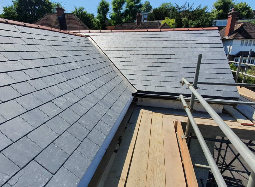 Natural slate roofing installation on a period property, showcasing expertly laid slate tiles and scaffolding for maintenance.