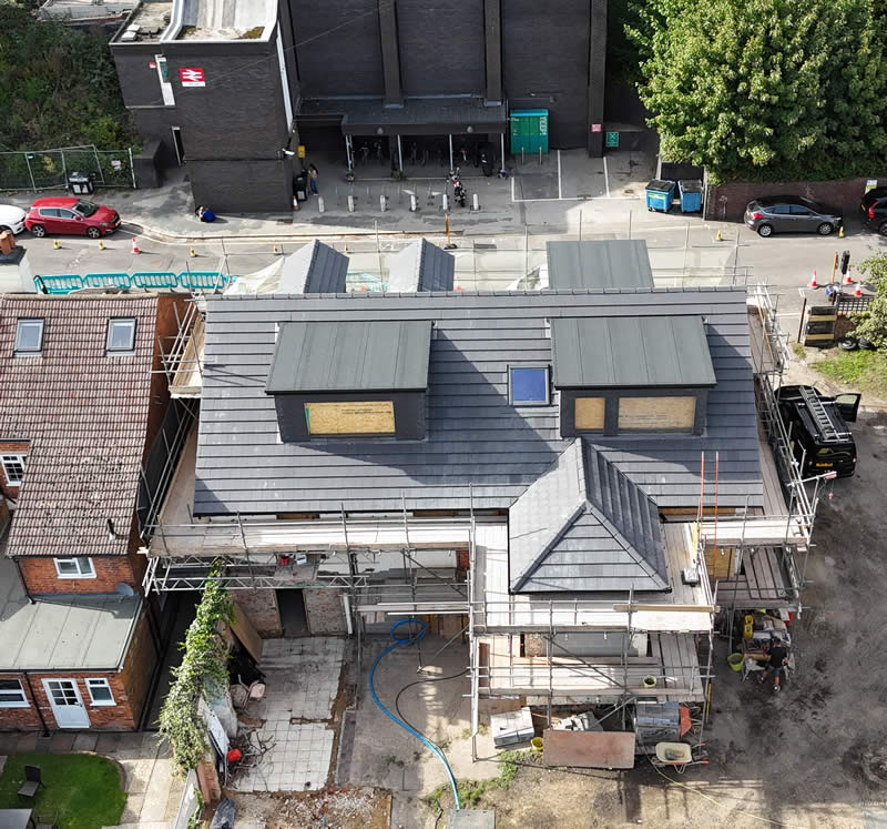 Roofing project featuring a newly installed slate roof with skylights and scaffolding, showcasing expert craftsmanship for domestic property renovations.